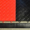 Close up of RaceDeck Garage Tile Border Corner Edges 1/2 Inch x 1.75x12 Inches in black with red and black Diamond Tuffshield