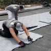 men installing outdoor court foundation panel over landscaping fabric