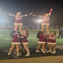 cheerleading at a football game with black cheer mats