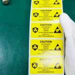 holding electrostatic caution sticker at static free workstation thumbnail