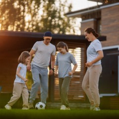 family playing on artificial turf outside at their home thumbnail