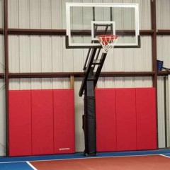 red wall pads installed in pole shed for home basketball