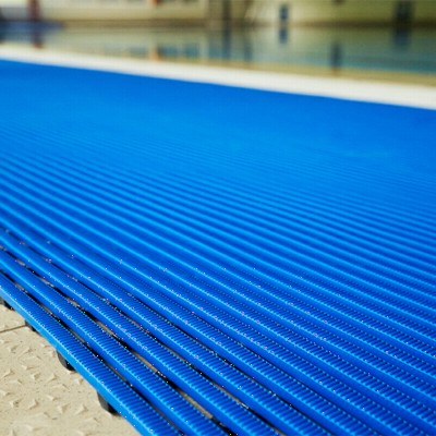 close up of blue Heronrib Wet Area Safety Matting Roll on poolside
