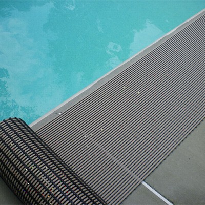 rolling out gray heronrib matting along poolside