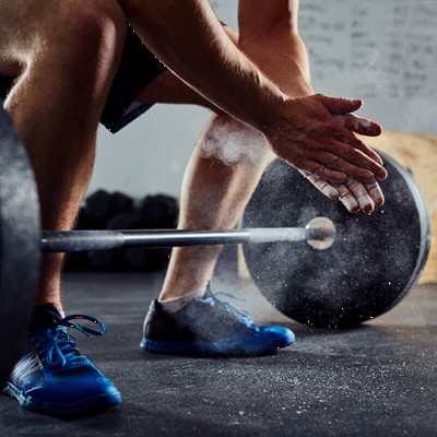 Man lifting with barbells over black rubber flooring
