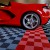 red corvette parked on perforated red black and gray garage floor tiles