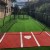 clay colored home plate mat in outdoor batting cage with green turf