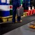 person carrying a jug on Flexigrid Industrial Matting 2 x 16.5 ft Roll in industrial shop